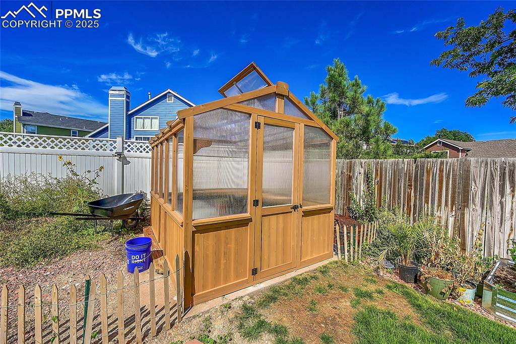 Image 37 of 39: View of greenhouse featuring a fenced backyard