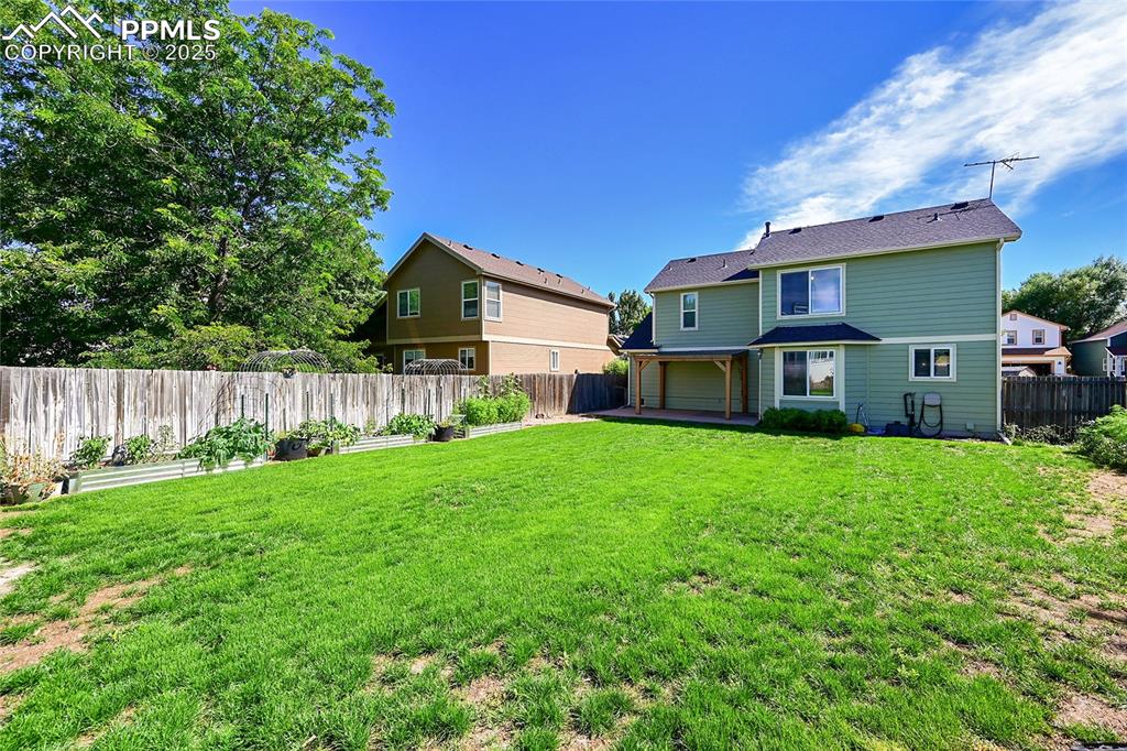 Image 38 of 39: Rear view of property with a patio, a fenced backyard, and a garage