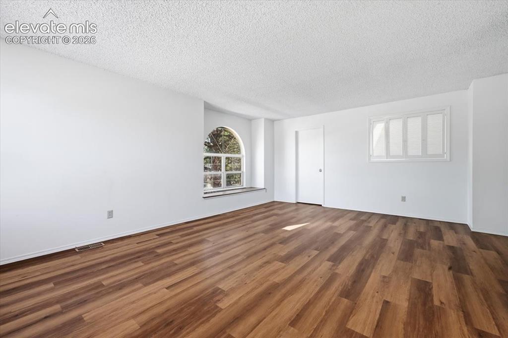 Image 17 of 26: Upper-level bedroom with an arched window and new LVP flooring at , Colorad