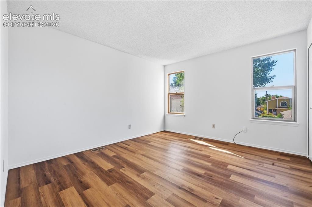 Image 18 of 26: Sunlit upper-level bedroom with new LVP flooring at , Colorado Springs, CO.