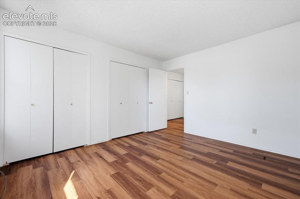 Image 19 of 26: Upper-level bedroom with double closets for extra storage at, Colorado Spri