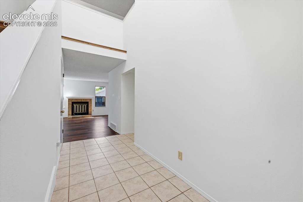 Image 4 of 26: Vaulted entry hall opens to the living room and wood-burning fireplace at ,