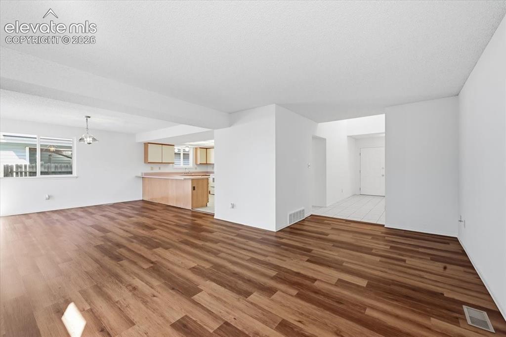 Image 8 of 26: Open-concept kitchen and living area flow with new flooring throughout at ,
