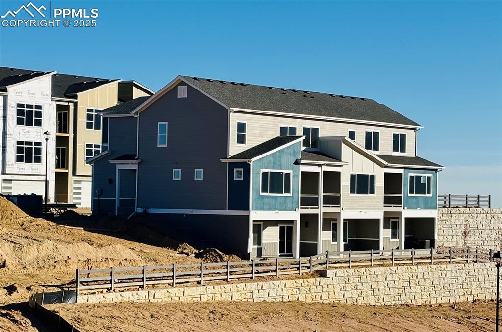 Image 5 of 21: Back of house featuring board and batten siding and a shingled roof