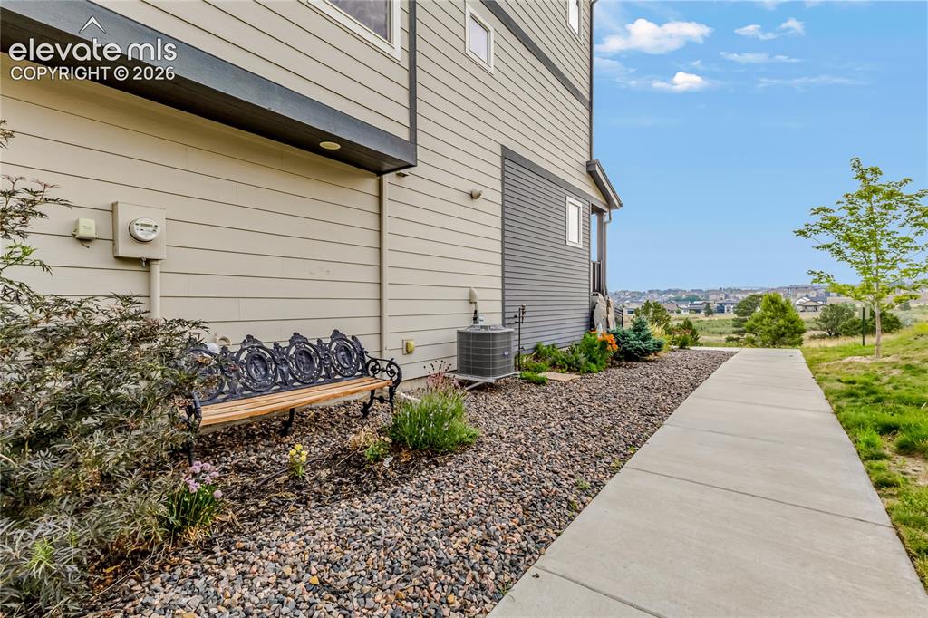 Image 35 of 45: Side pathway to front door. Views of open space, ponds, and Rocky Mountains