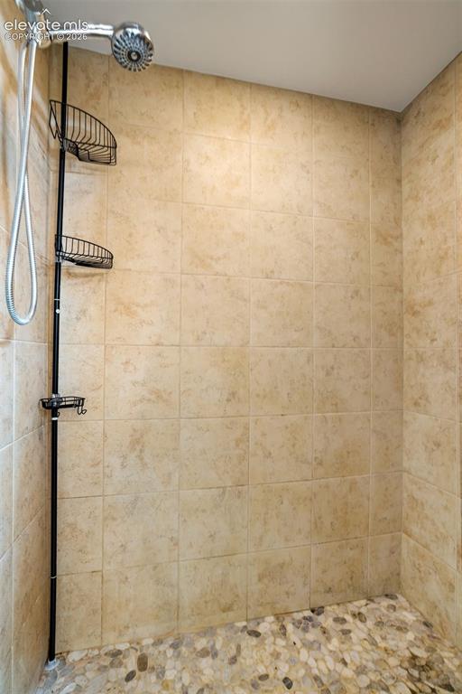 Image 36 of 46: Shower with stone floor in the upstairs bathroom.