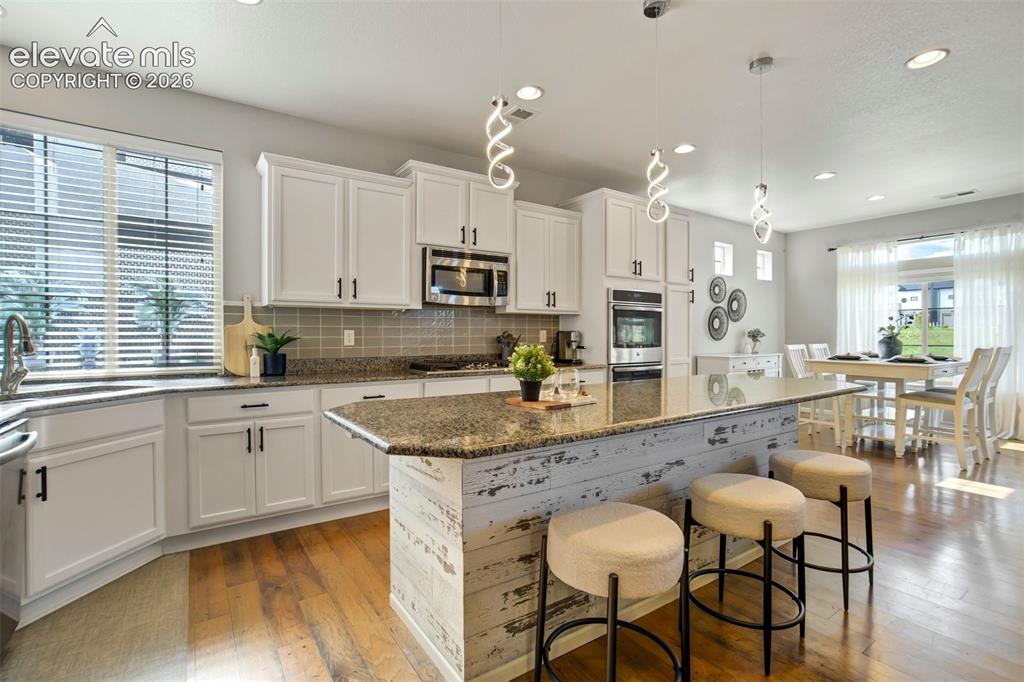 Image 9 of 46: A kitchen that delivers. Granite, gas range, double ovens, and an island th