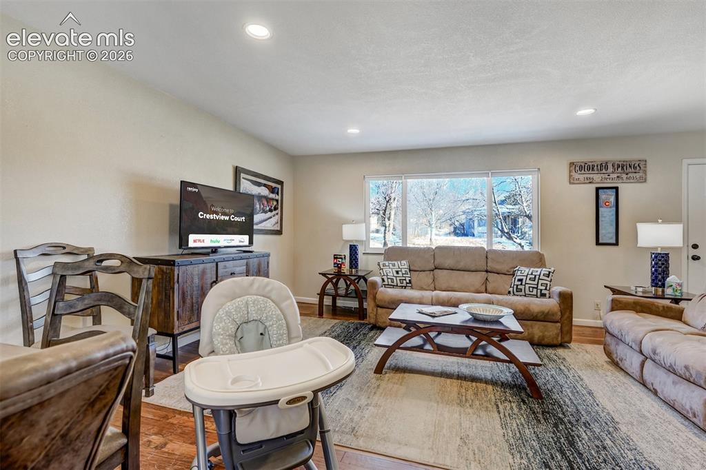 Image 10 of 43: Recessed ceiling lighting, wood-finish flooring, and expansive windows