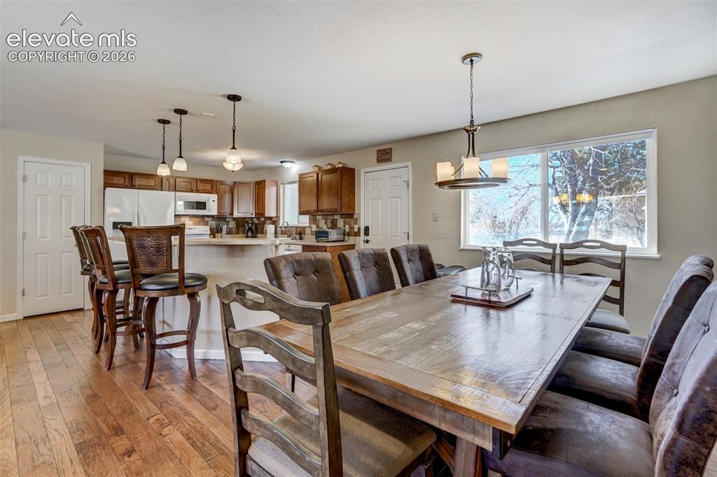 Image 11 of 43: Wood-finish flooring, recessed lighting, white appliances, built-in cabinet