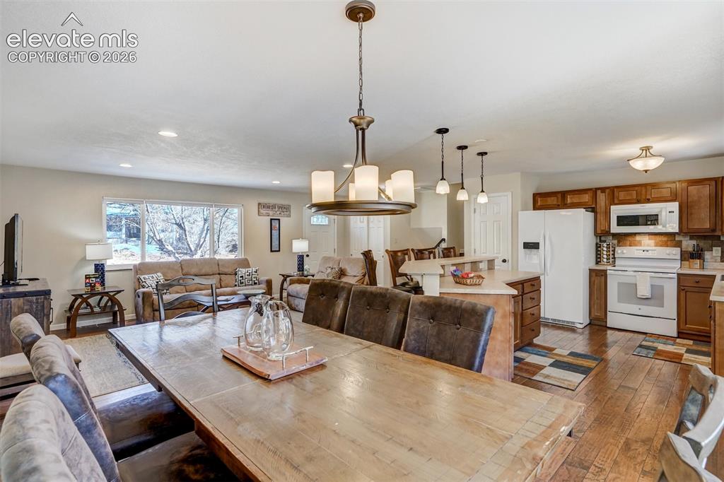 Image 12 of 43: Open-concept living area with wood-finish flooring, recessed lighting, and 