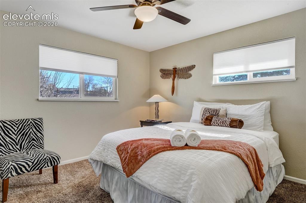 Image 14 of 43: Ceiling fan with integrated lighting, two windows with blinds, and textured