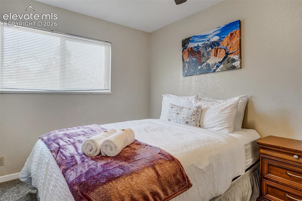 Image 16 of 43: Recessed window with blinds, textured walls, and a ceiling fan