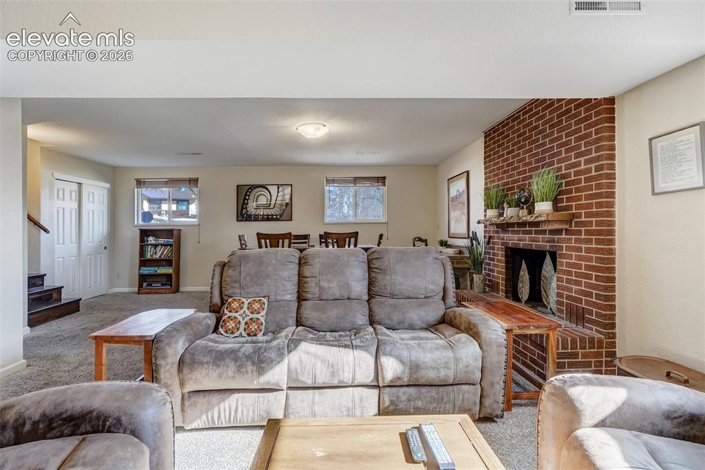 Image 24 of 43: Brick-clad fireplace with a wood mantel