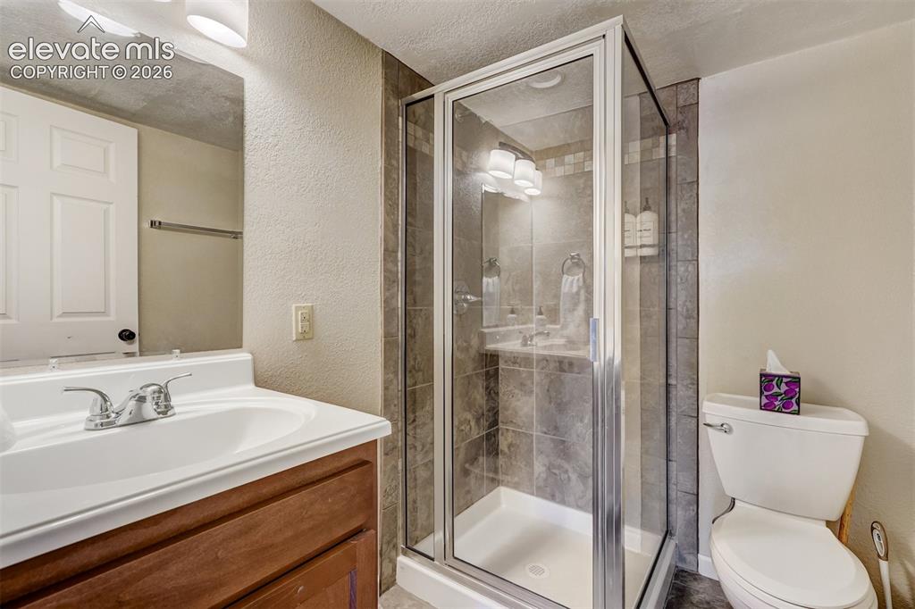 Image 25 of 43: Glass-enclosed shower with tiled walls and a built-in niche