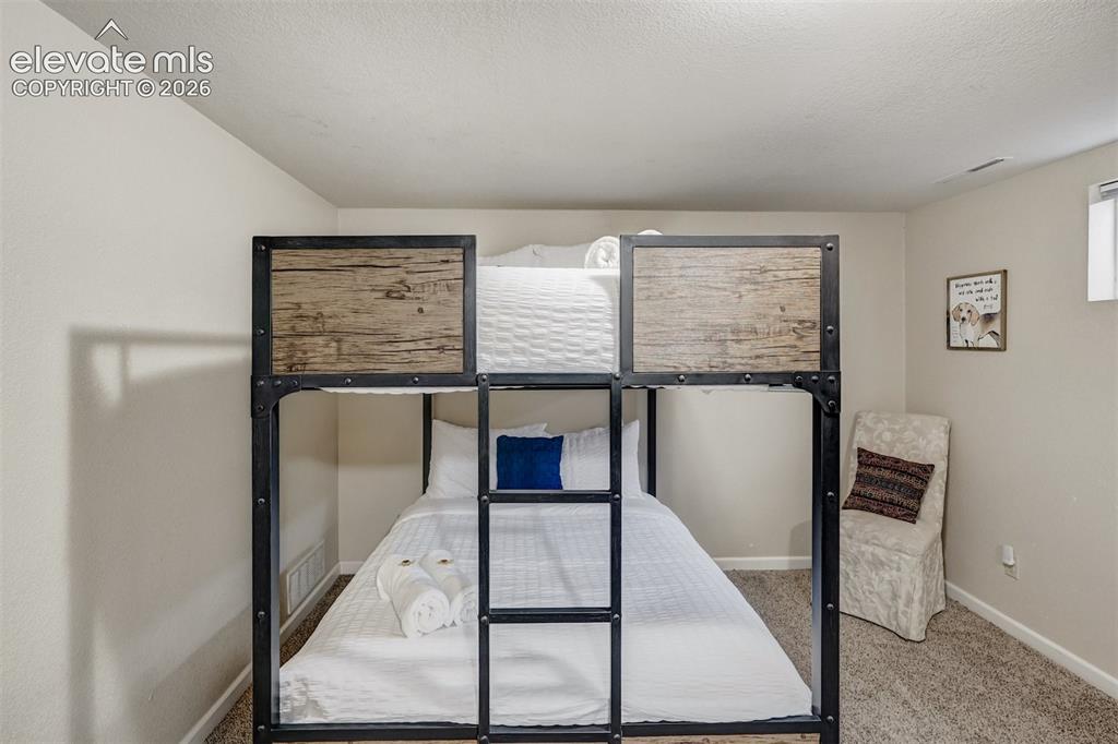 Image 28 of 43: Industrial-style bunk bed featuring a metal frame and wood-finish panels