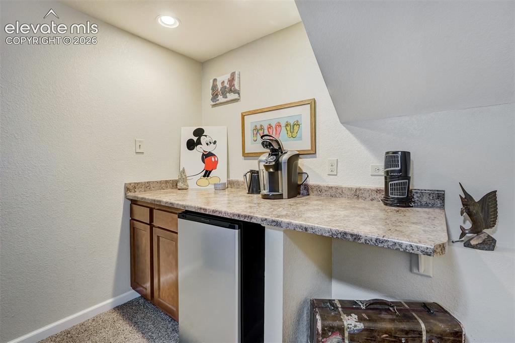 Image 29 of 43: Built-in cabinetry with a countertop, integrated compact refrigerator, and