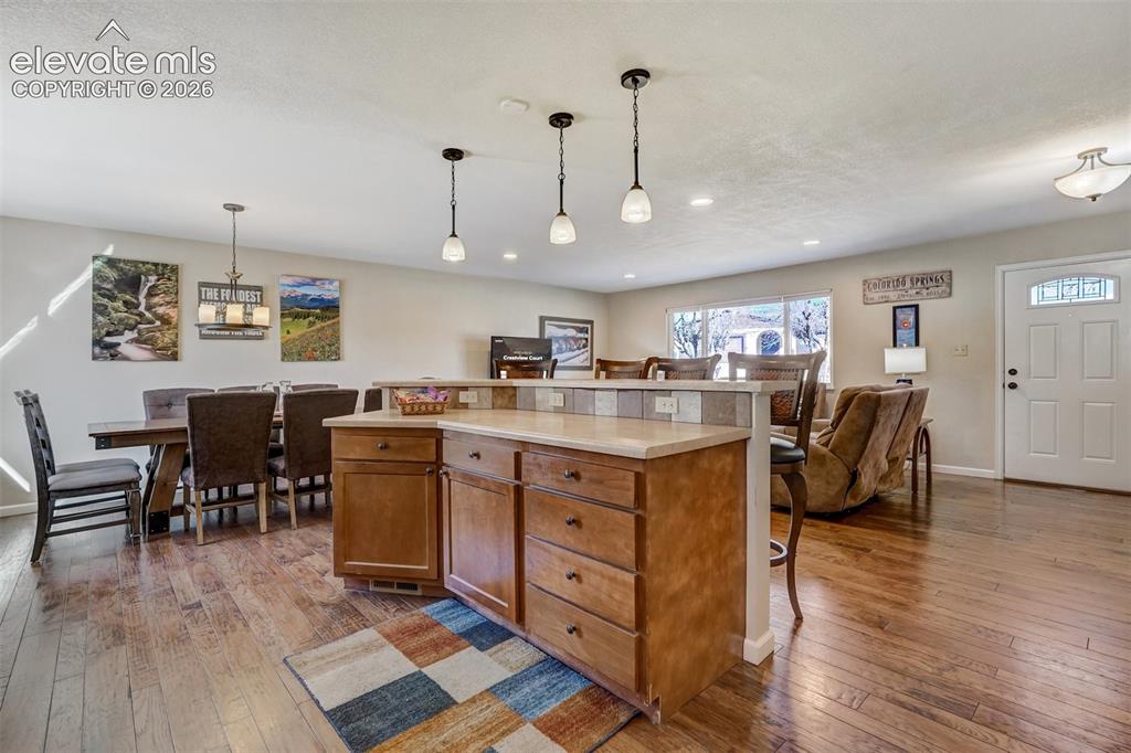Image 3 of 43: Open-concept living area featuring wood-finish flooring, a kitchen island w