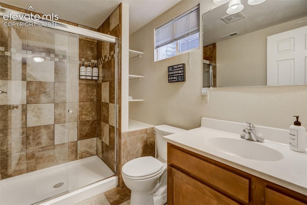 Image 31 of 43: Bathroom featuring a glass-enclosed shower with tile surround, a single-sin