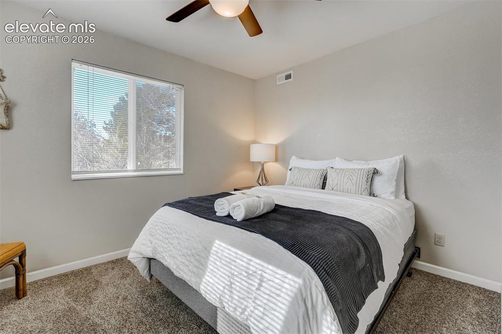 Image 36 of 43: Carpeted room with a ceiling fan, a window with blinds, and neutral wall to
