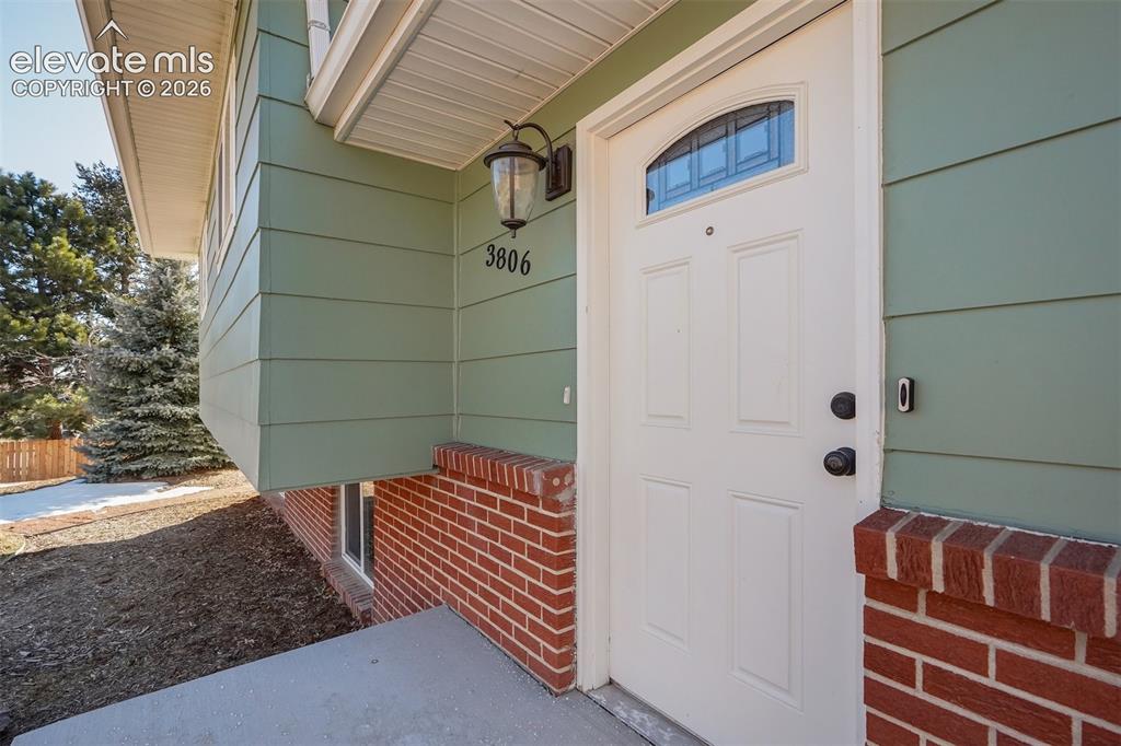 Image 39 of 43: Exterior featuring light green siding, a white front door with an arched wi