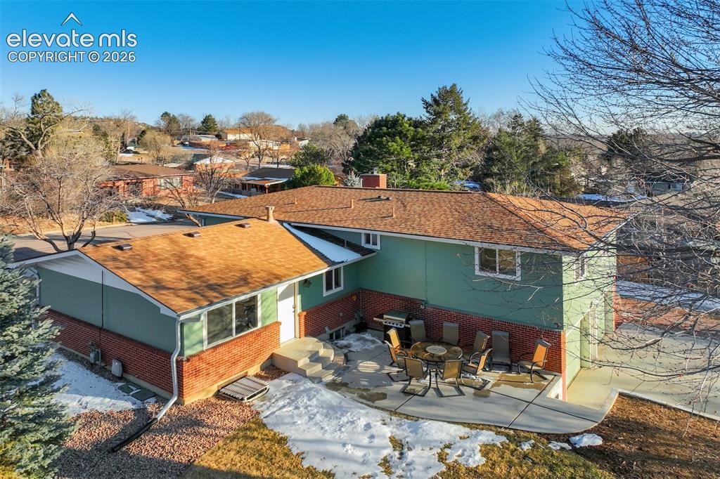 Image 41 of 43: Two-story exterior with brick and siding facade, featuring a patio area, mu