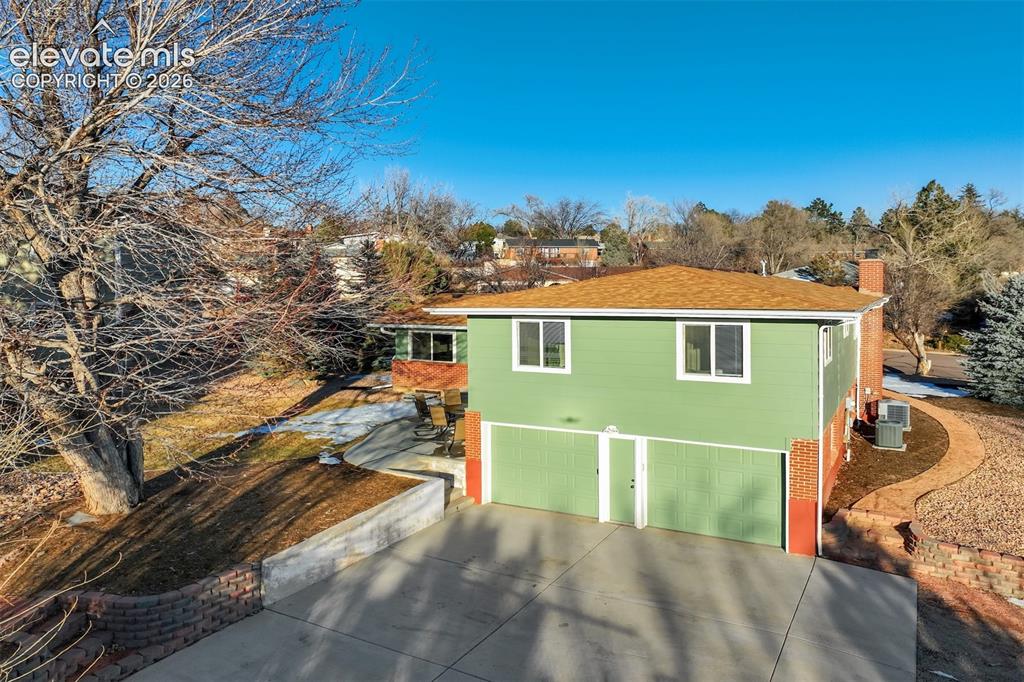 Image 42 of 43: Two-story residence with a two-car garage, light green exterior siding, and