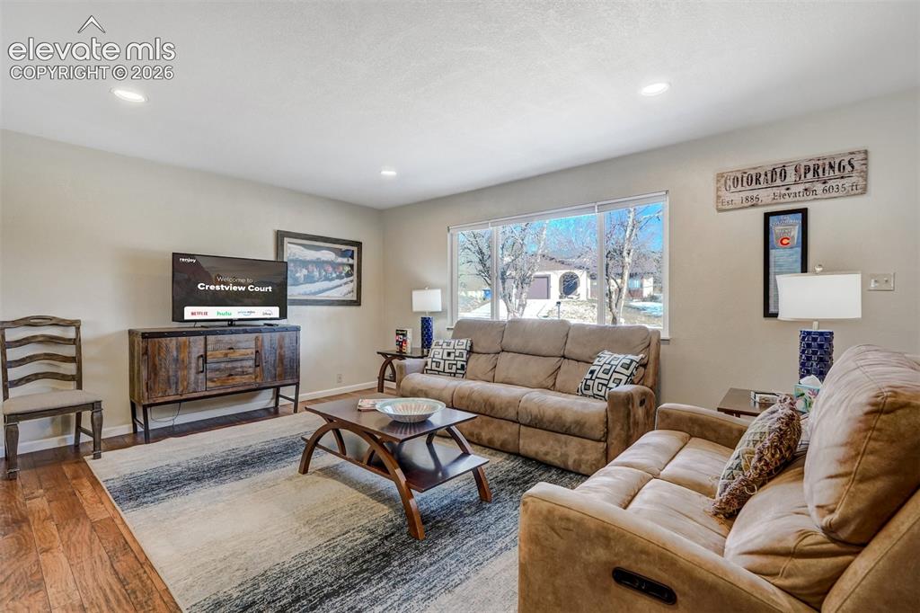 Image 6 of 43: Recessed lighting, wood-finish flooring, a large window, and light-toned wa
