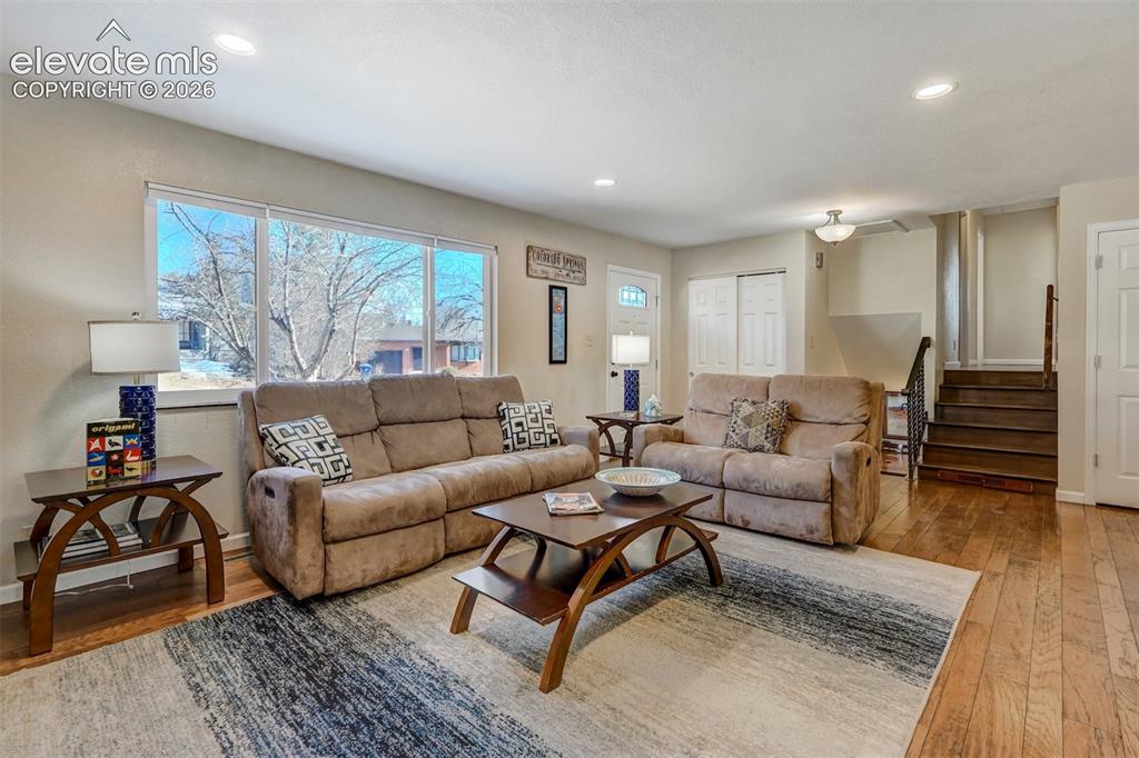 Image 7 of 43: Hardwood flooring, recessed lighting, large picture windows, white trim, an