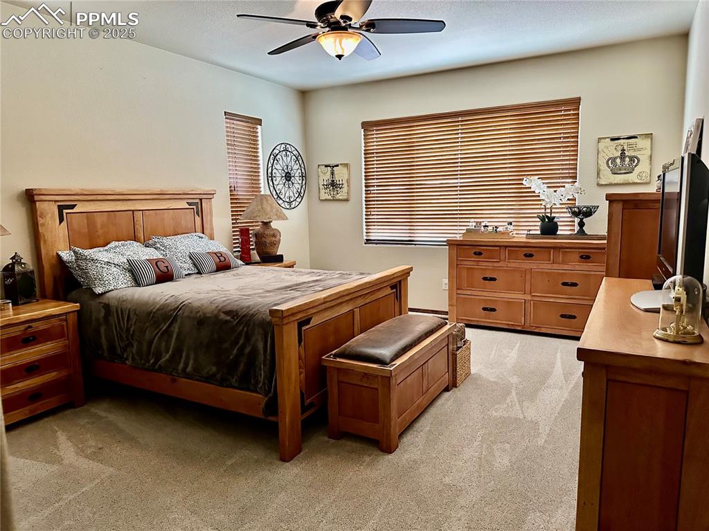 Image 13 of 33: Bedroom with light colored carpet and ceiling fan