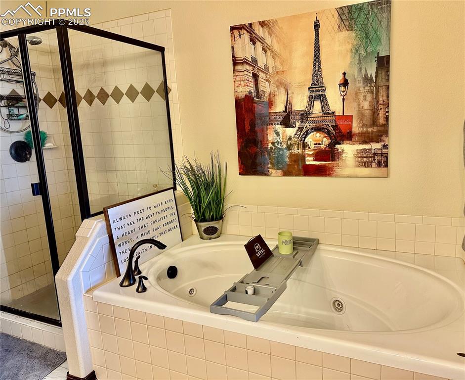 Image 15 of 33: Bathroom with a shower stall and a jetted tub