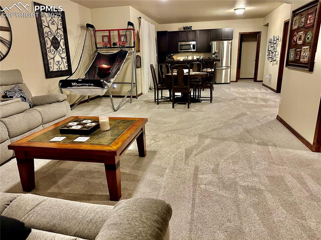 Image 18 of 33: Living area featuring light colored carpet and baseboards