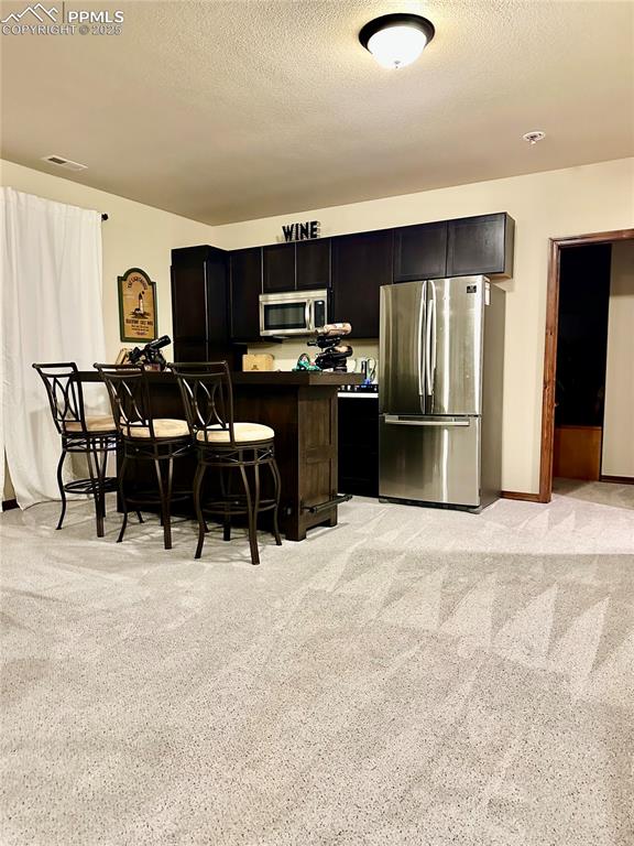 Image 21 of 33: Kitchen featuring light colored carpet, appliances with stainless steel fin