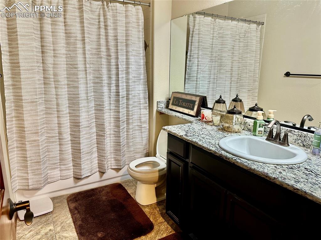 Image 28 of 33: Bathroom with vanity, shower / bath combo with shower curtain, and tile pat
