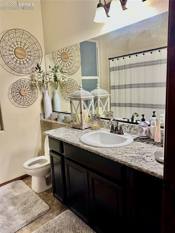 Image 29 of 33: Full bathroom featuring vanity and a textured wall