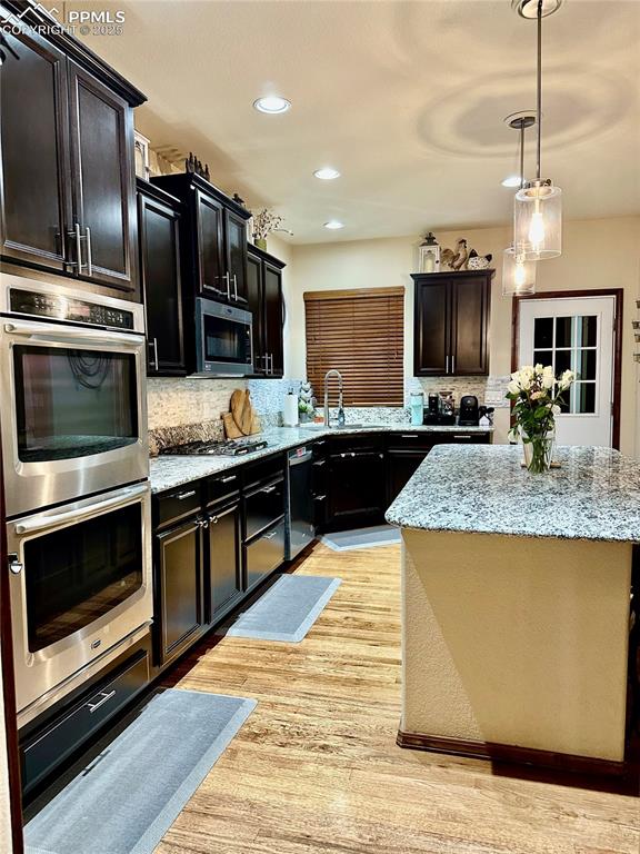 Image 5 of 33: Kitchen with backsplash, appliances with stainless steel finishes, recessed