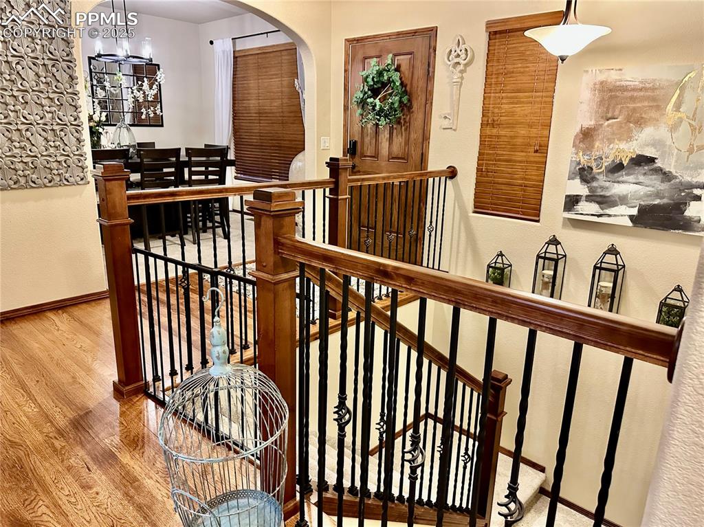 Image 8 of 33: Hallway featuring a textured wall, wood finished floors, an upstairs landin