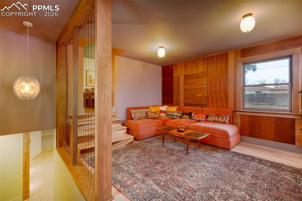Image 13 of 50: Family room with custom built paneling and custom built wood stairs up to t