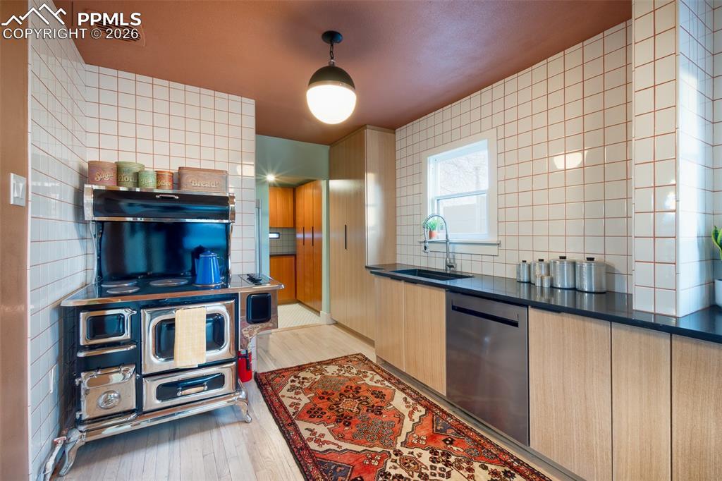 Image 17 of 50: Kitchen with retro stove and custom built white oak cabinets, mahagony in t