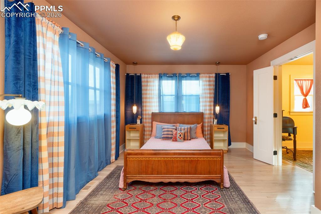 Image 20 of 50: Primary bedroom with hand selected vintage fixtures and French doors to the