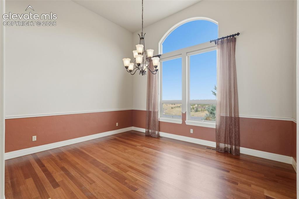 Image 11 of 50: Spacious interior featuring a vaulted ceiling and a large arched window