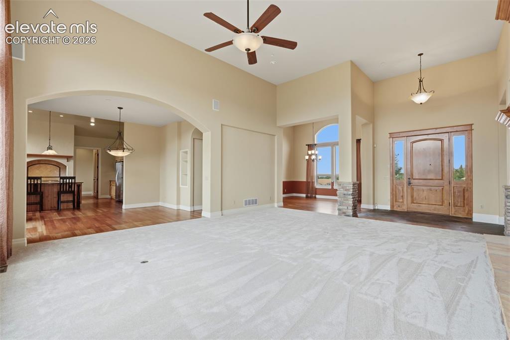 Image 15 of 50: Spacious interior featuring a grand entryway with a solid wood door and sid
