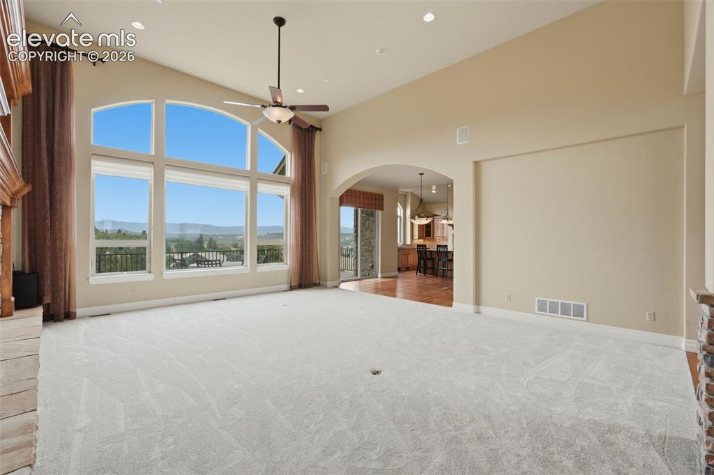 Image 17 of 50: Spacious living area featuring expansive arched windows, high vaulted ceili