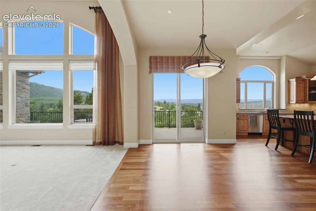 Image 19 of 50: Spacious open-concept living area featuring large arched windows, wood-fini