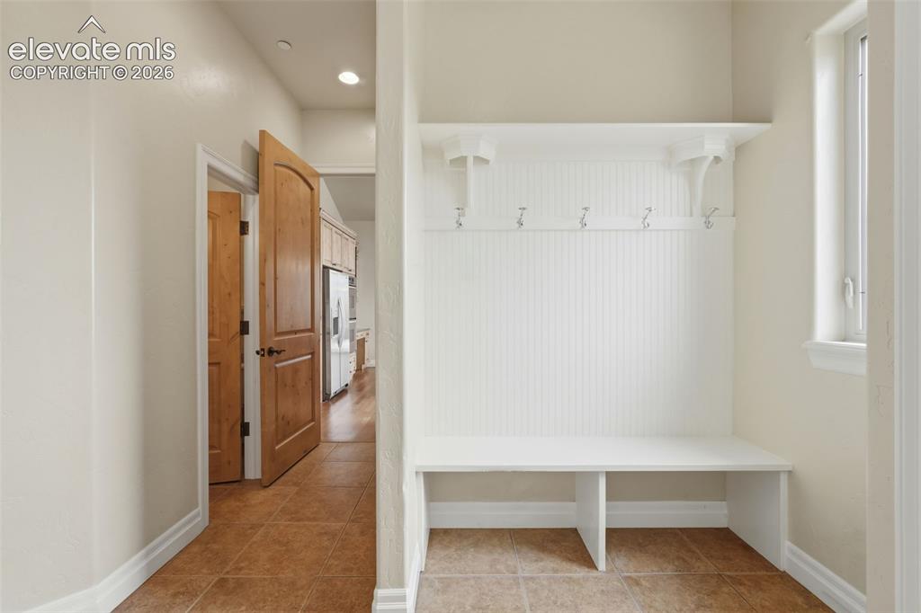 Image 25 of 50: Built-in mudroom bench with beadboard backing and wall hooks