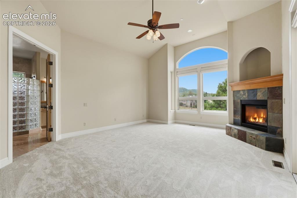 Image 32 of 50: Spacious room featuring vaulted ceilings, an arched window with expansive o