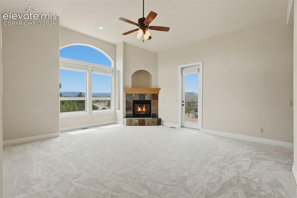 Image 33 of 50: Spacious interior with vaulted ceilings, a corner stone fireplace, and a ce