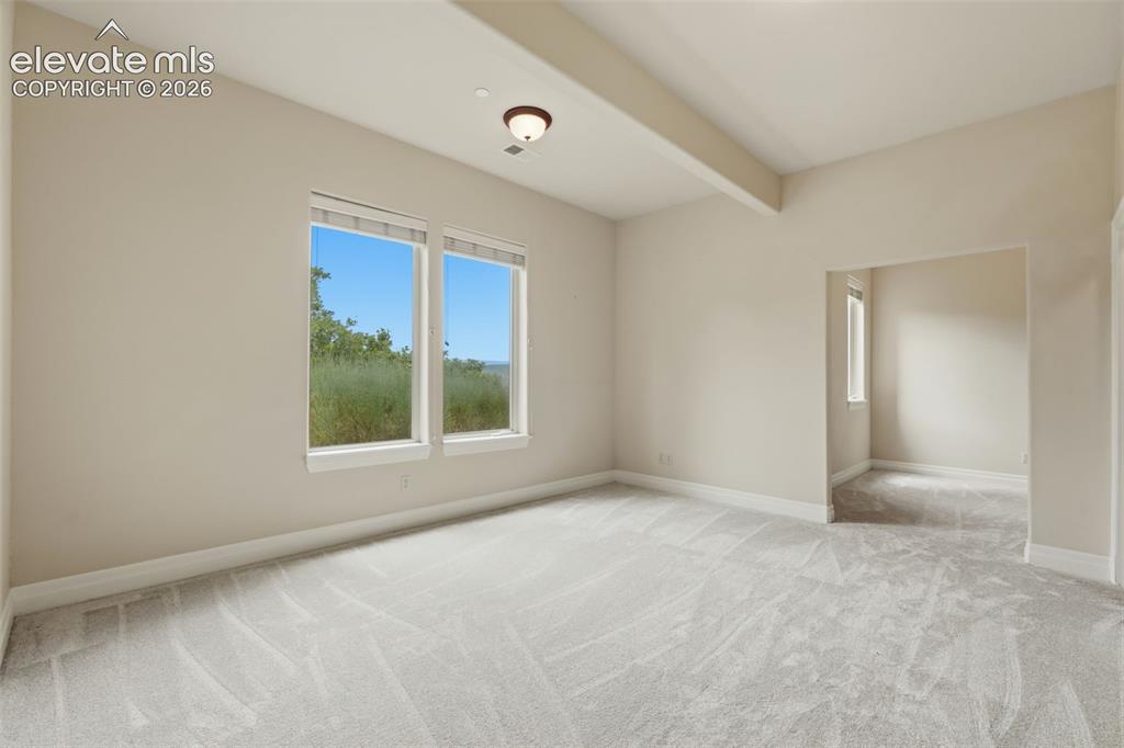 Image 44 of 50: Spacious room featuring neutral carpeting, light-toned walls, and a ceiling