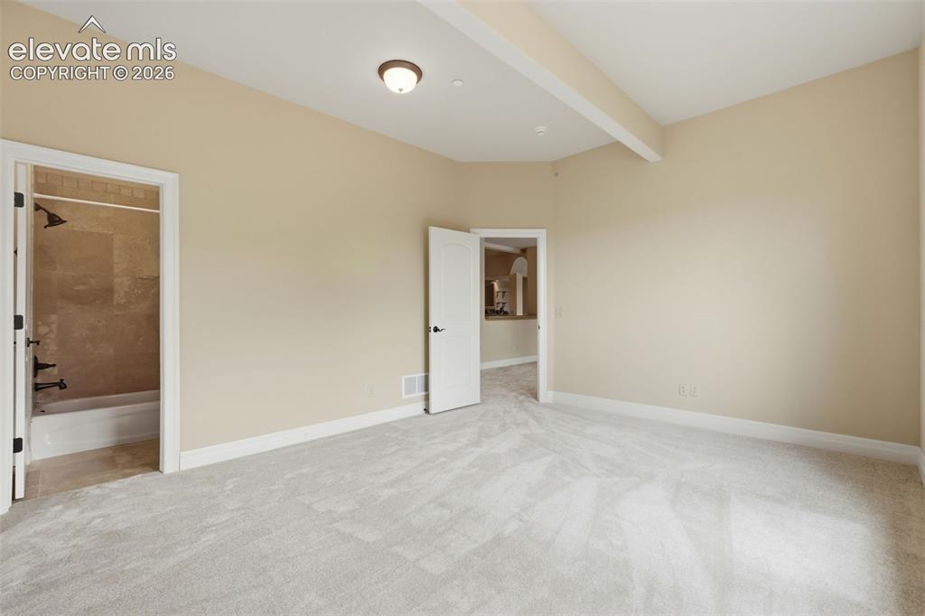 Image 47 of 50: Spacious room with plush gray carpeting, light neutral wall paint, and whit