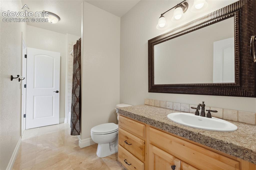Image 48 of 50: Bathroom vanity with a granite-look countertop, integrated oval sink, and b