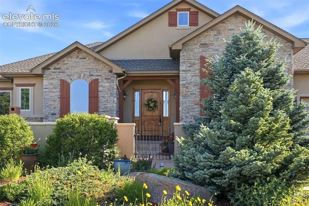 Image 6 of 50: Stone and stucco exterior with arched window shutters